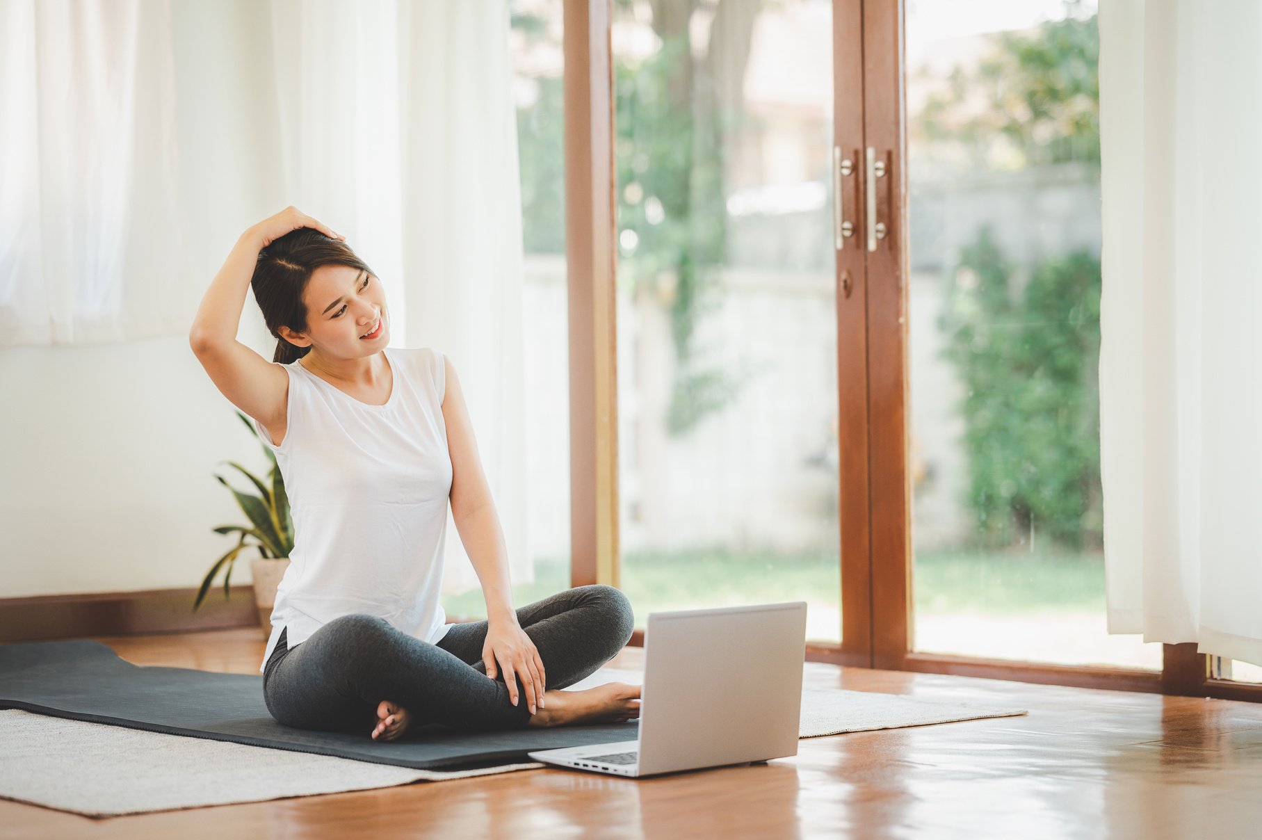 Asian Woman Doing Yoga Neck Stretching Online Class at Home